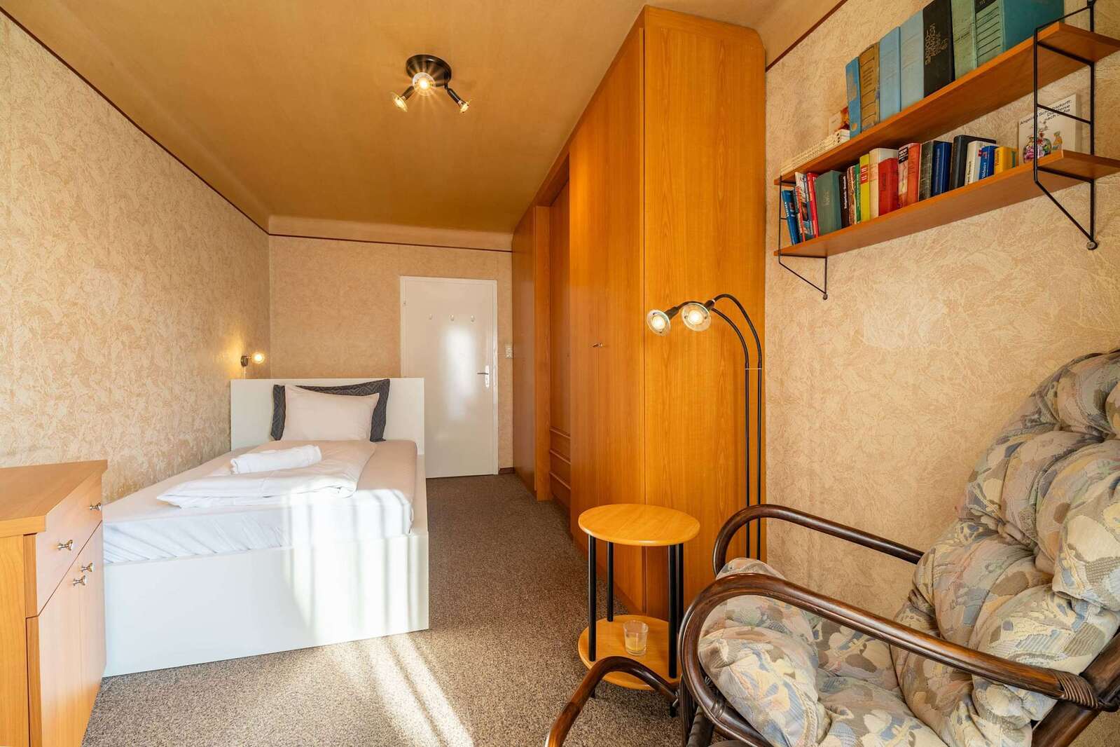 Second Bedroom in Natural Light - Spacious, Carpeted, with a Rocking Chair for Reading or Reflection