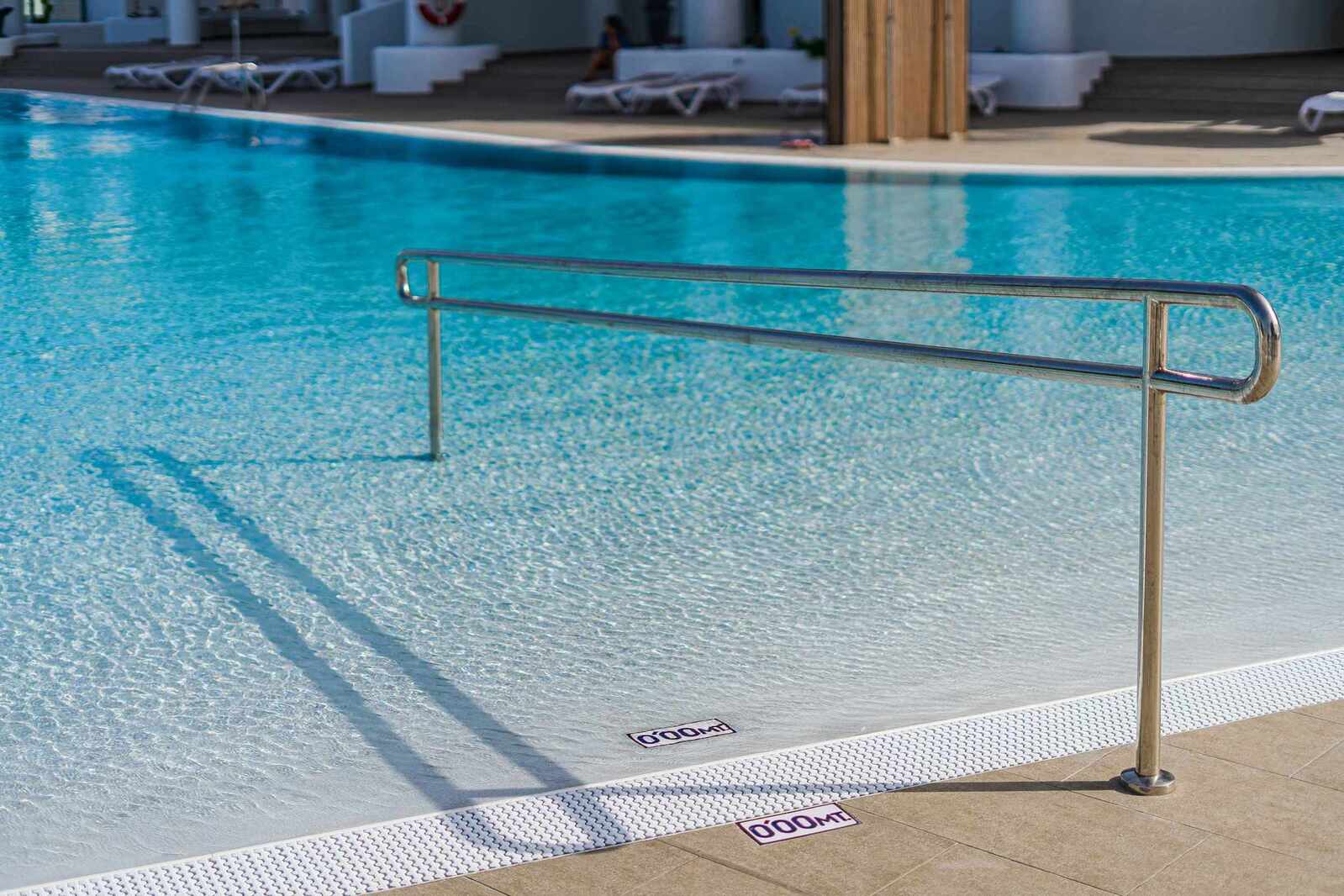Resort-Style Pool Area with Sun Loungers and Open-Air Relaxation Space