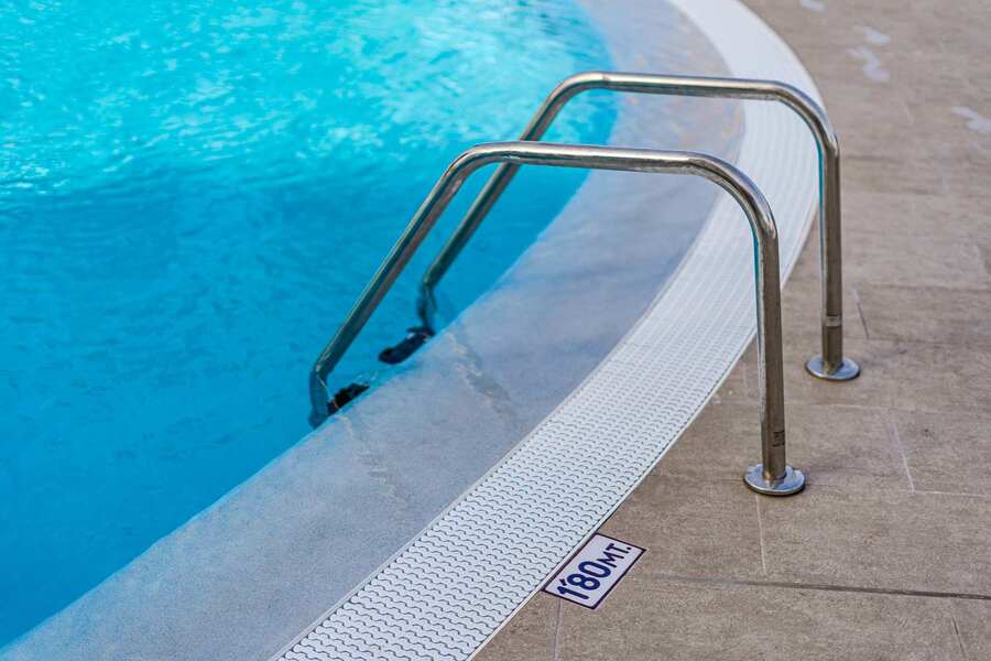 Resort-Style Pool Area with Sun Loungers and Open-Air Relaxation Space