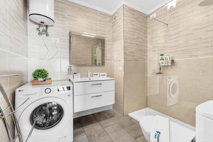 Bathroom with Toilet, Multi-Jet Shower, Sink and Washing Machine 