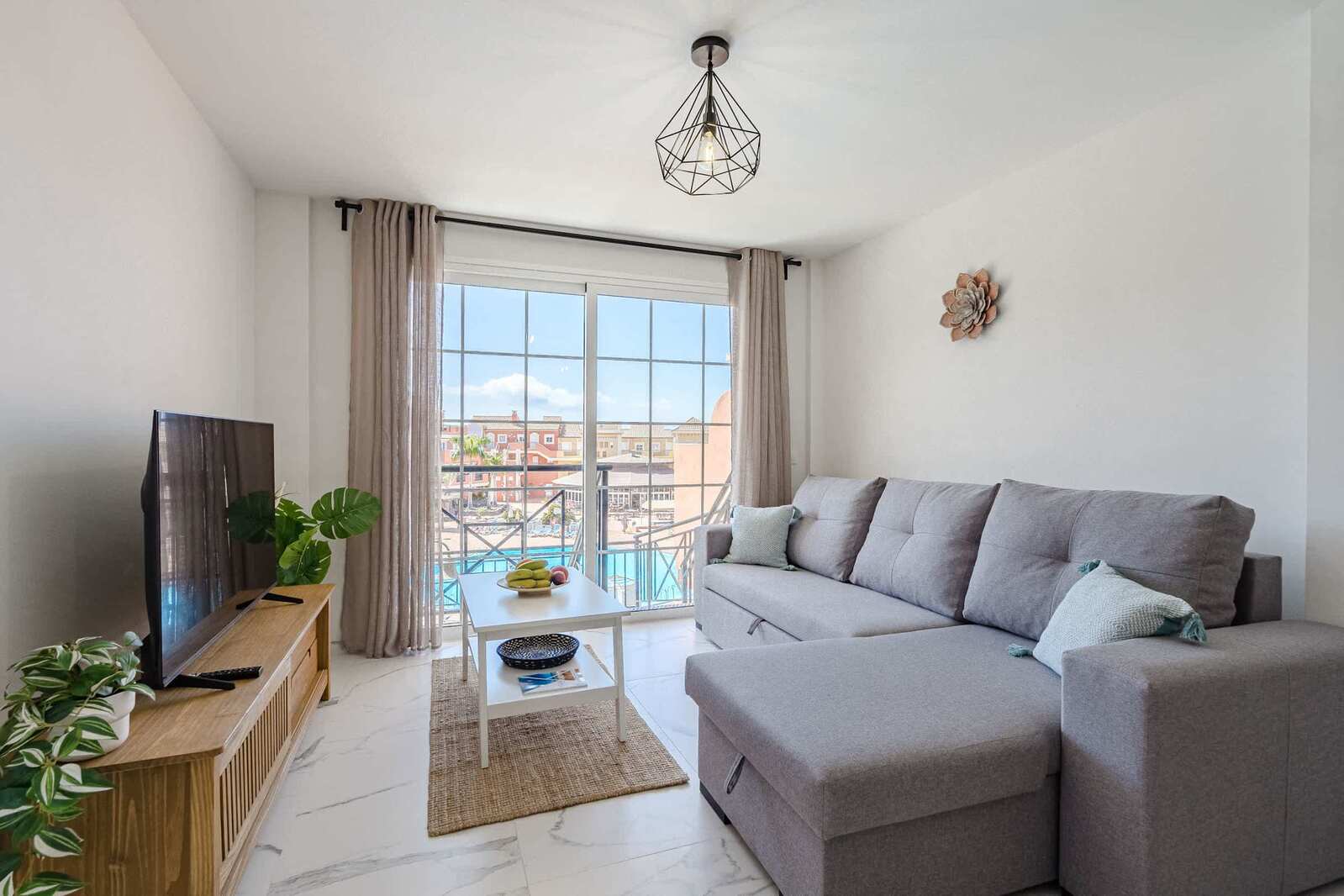 Living Room with TV, Sofa Bed, Dining Table, Coffee Table and Pool View