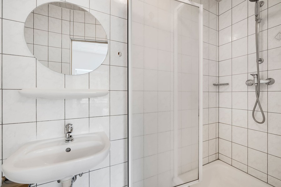Bathroom with Walk-in Shower and Round Mirror.