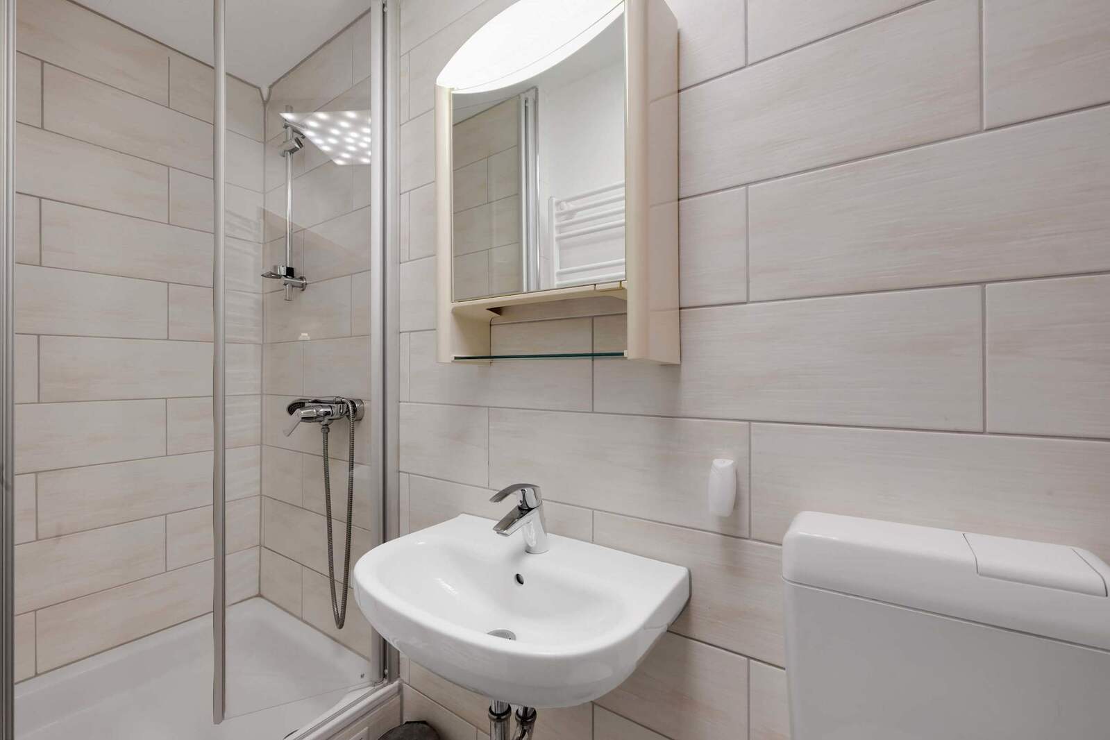Bright Bathroom with Walk-In Shower and Mirror Cabinet.