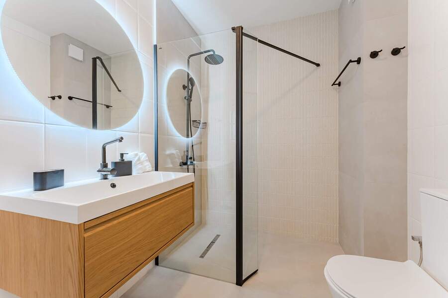 Contemporary Bathroom Featuring Walk-In Rain Shower, Backlit LED Mirror, and Sleek Designer Fixtures