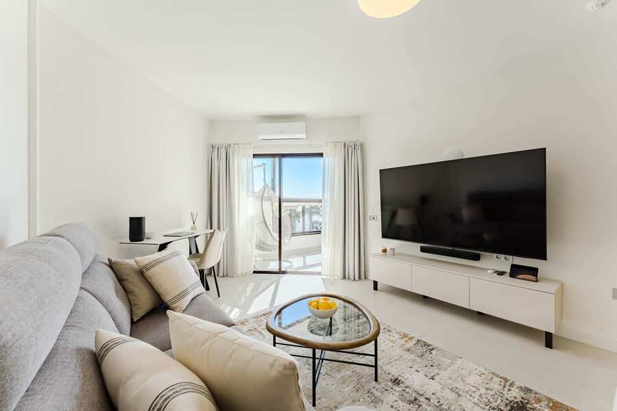 Bright Oceanfront Living Room with Designer Sofa, Oversized Flatscreen TV, Apple TV, Sonos Sound System & Elegant Workspace