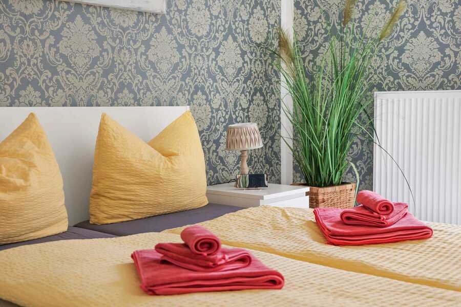 Inviting Bed Setup with Soft Linens | Elegant Wallpaper & Natural Decor Touches