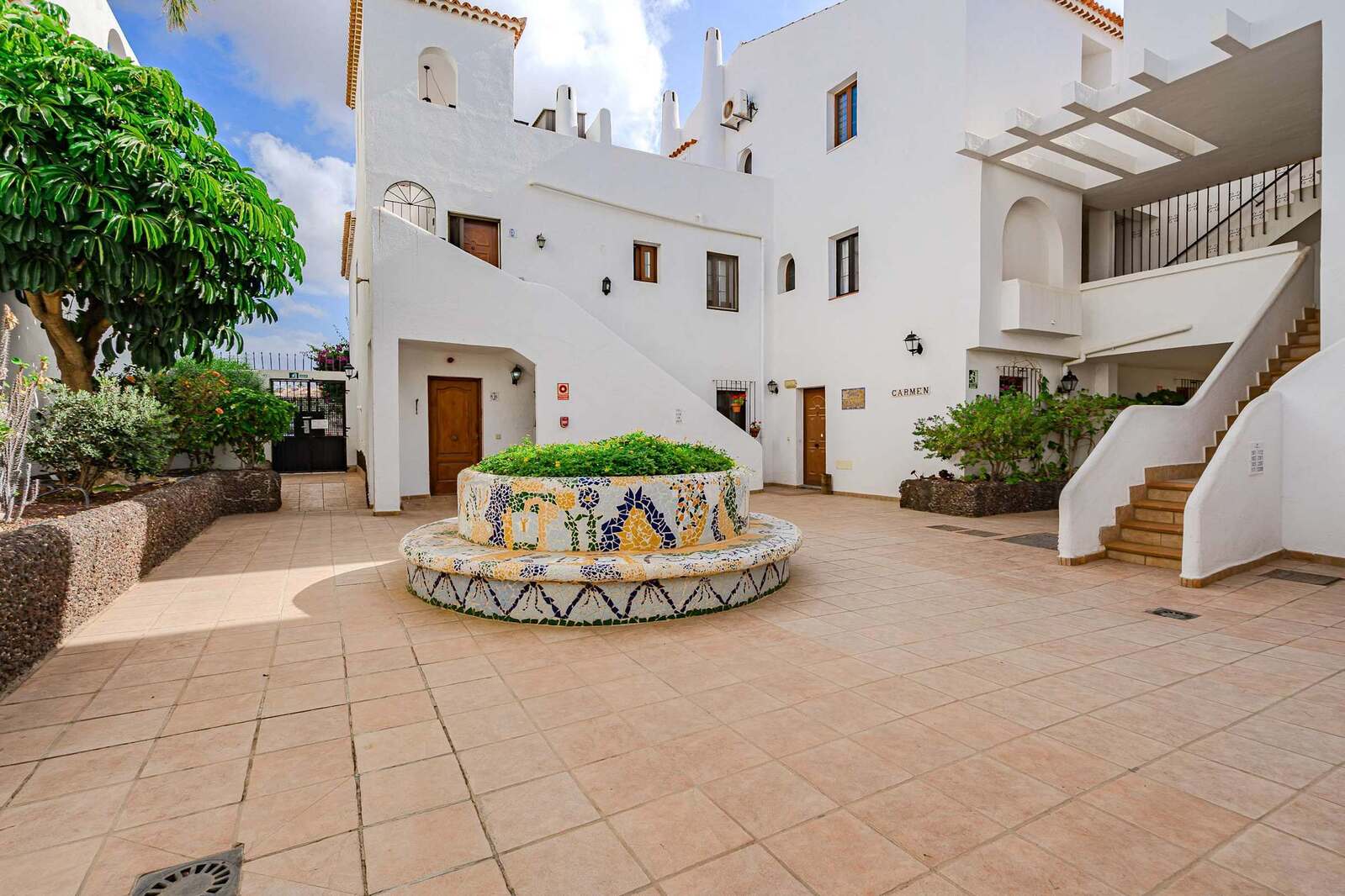 Traditional Courtyard with Mosaic — A Colorful Slice of Canary Island Charm Framed by Lush Greenery and Whitewashed Walls