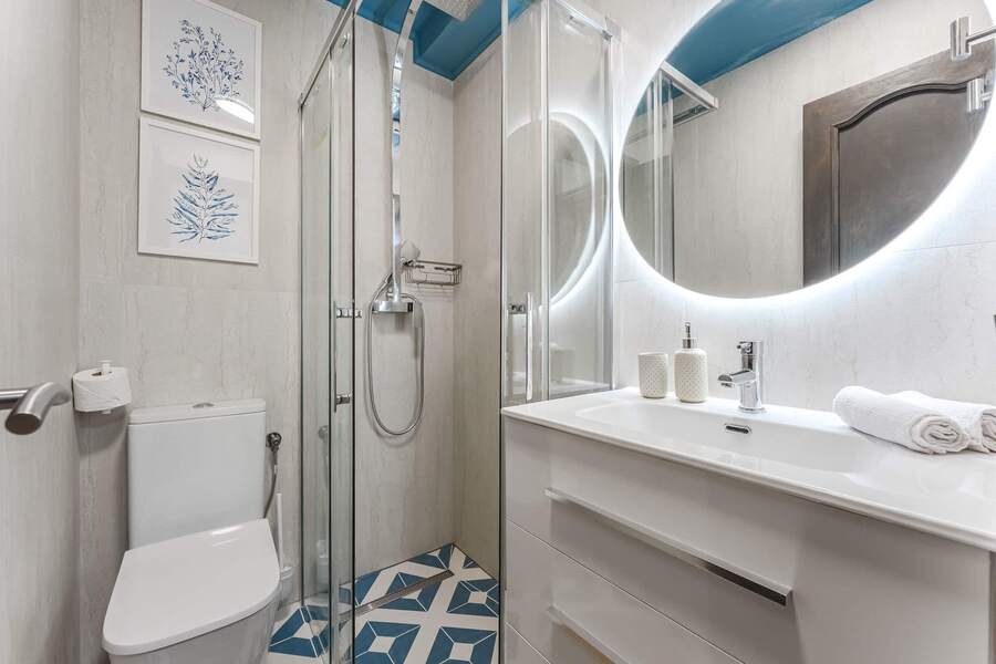 Second Bathroom with Sleek Glass Shower — A Bright, Modern Space with Illuminated Mirror & Artistic Coastal Accents