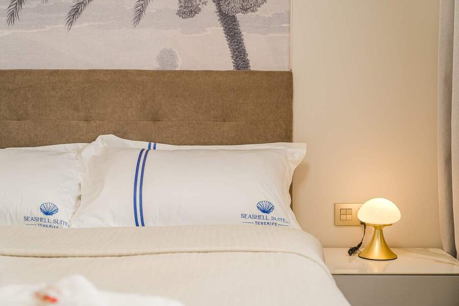 Soft Bedding & Palm Wall Art – Relaxing Retreat with a Coastal Atmosphere