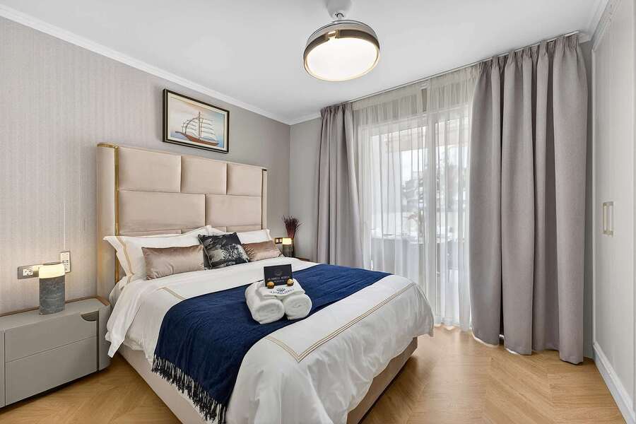 Tranquil Second Bedroom with Sea-Inspired Tones — Wake Refreshed in a Coastal Retreat with Soft Drapes and Plush Bedding