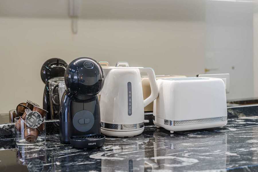 Curated Kitchen Essentials – Enjoy Mornings with a Sleek Espresso Machine, Retro Kettle and Toaster on Marble Counters