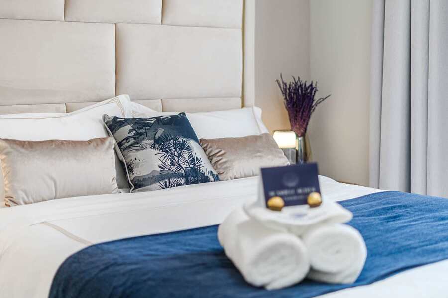 Tranquil Second Bedroom with Sea-Inspired Tones — Wake Refreshed in a Coastal Retreat with Soft Drapes and Plush Bedding