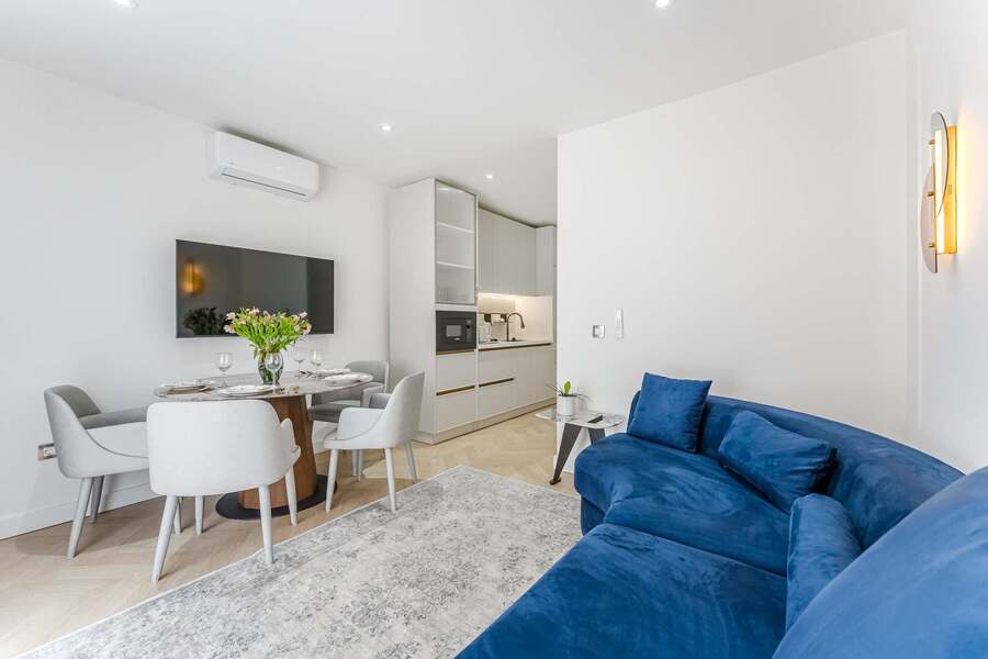 Elegant open-plan Living Room with Modern Velvet Sofa, Soft Lighting & Smart TV – ideal for Stylish Evenings in Playa San Juan