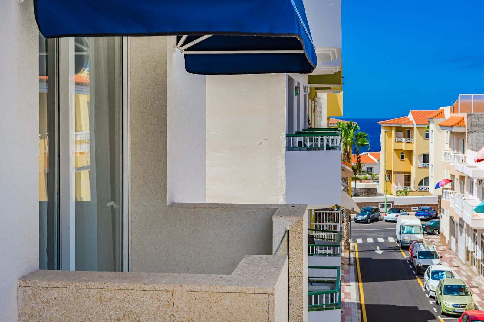 Balcony Escape with Blue Awning and Peek of the Atlantic – Breathe in the Coastal Breeze