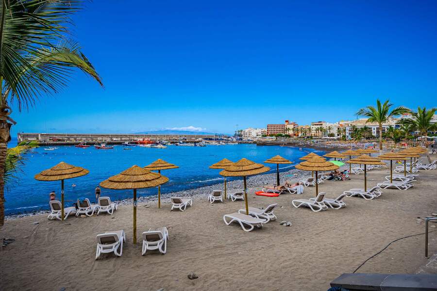 Sun-Drenched Shores – Relax Under Straw Parasols with Ocean Views