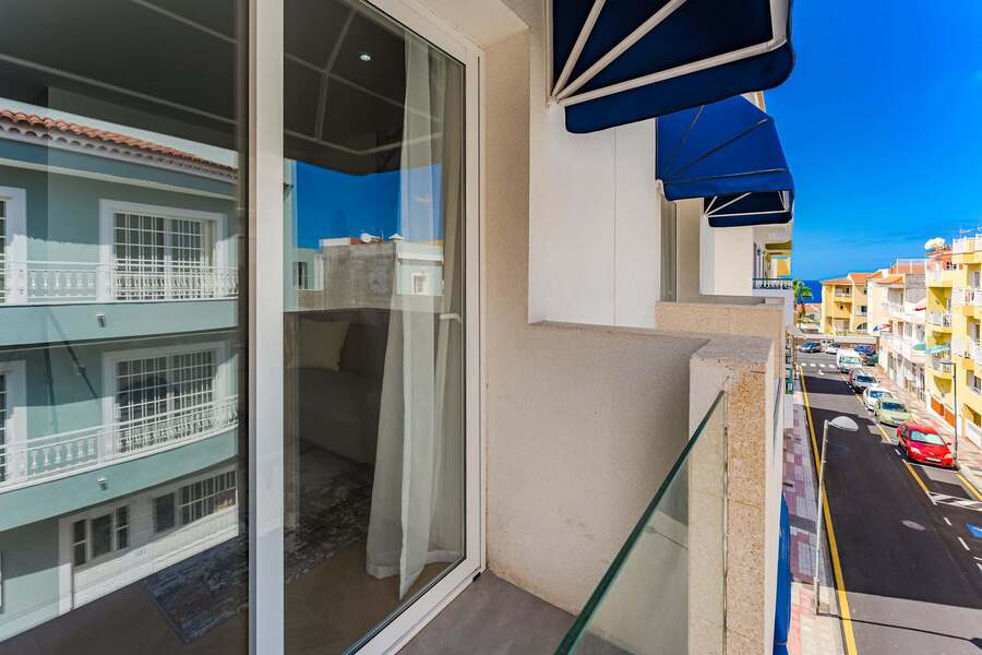 Ocean Peeking Through the Streets — Balcony View With Coastal Horizon
