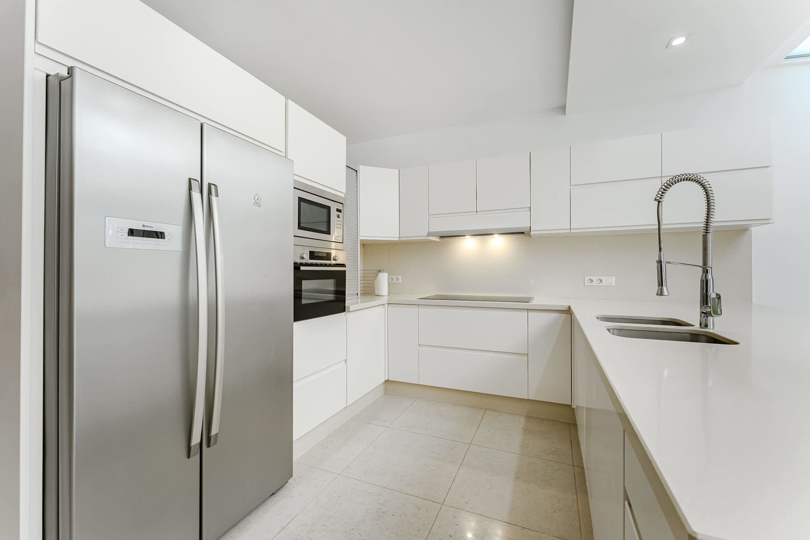 Sleek Modern Kitchen with Full-Size Stainless Steel Appliances, Generous Countertops, and Minimalist White Cabinetry