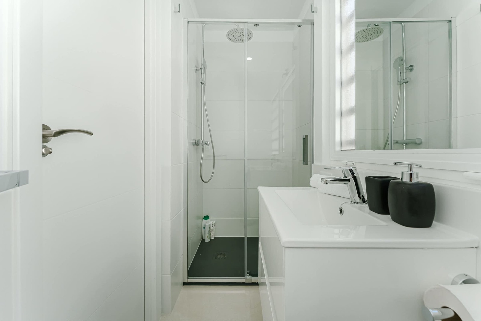 Minimalist Third Bathroom with Glass Shower, Backlit Mirror, and Matte Black Accessories for a Modern Spa Feel