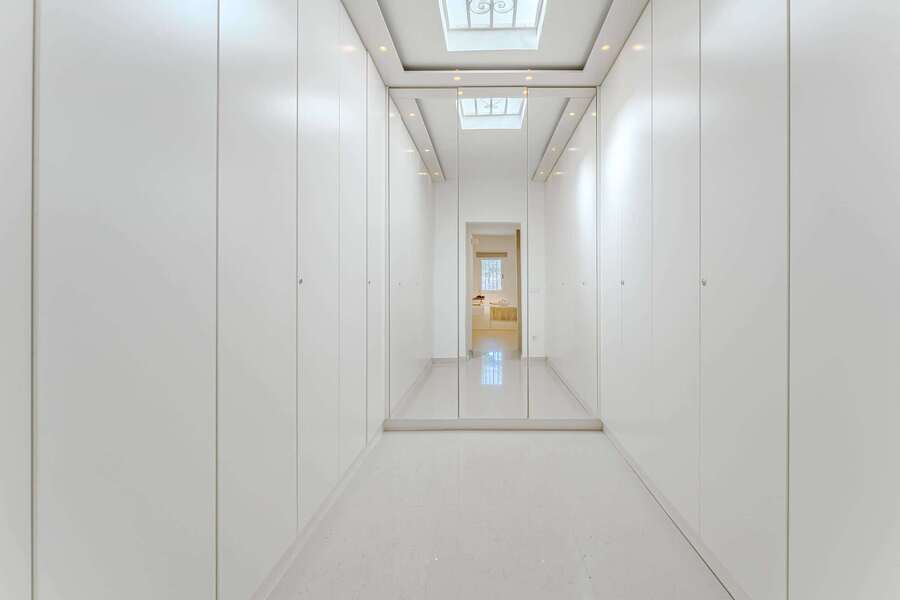 Minimalist Walk-In Closet with Full-Length Mirrors and Skylight – A Bright and Spacious Dressing Retreat