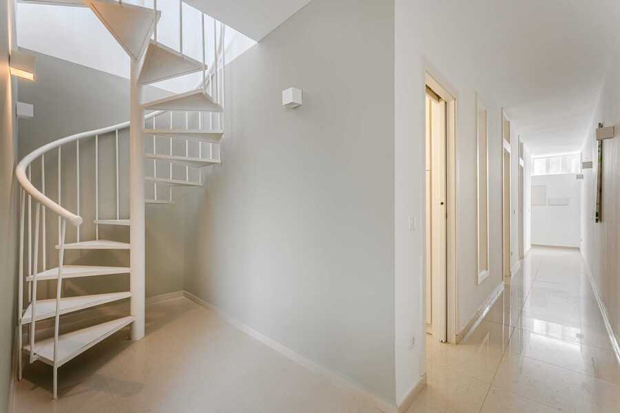 Architectural Spiral Staircase with Soft Grey Accent Wall – A Stylish Transition Between Ground and Rooftop Levels