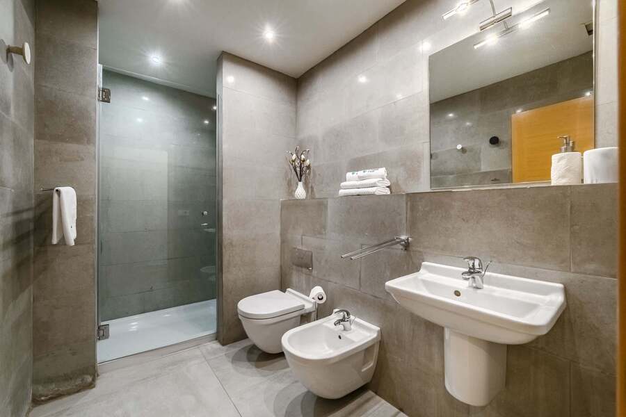 Modern Bathroom with Elegant Grey Tiles - Enjoy a Refreshing Rain Shower and Premium Amenities 