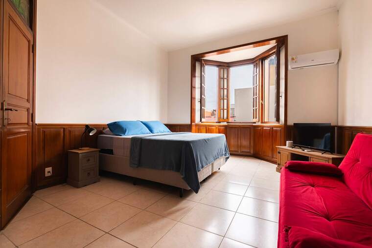Bedroom with Queen Bed and Red Sofa