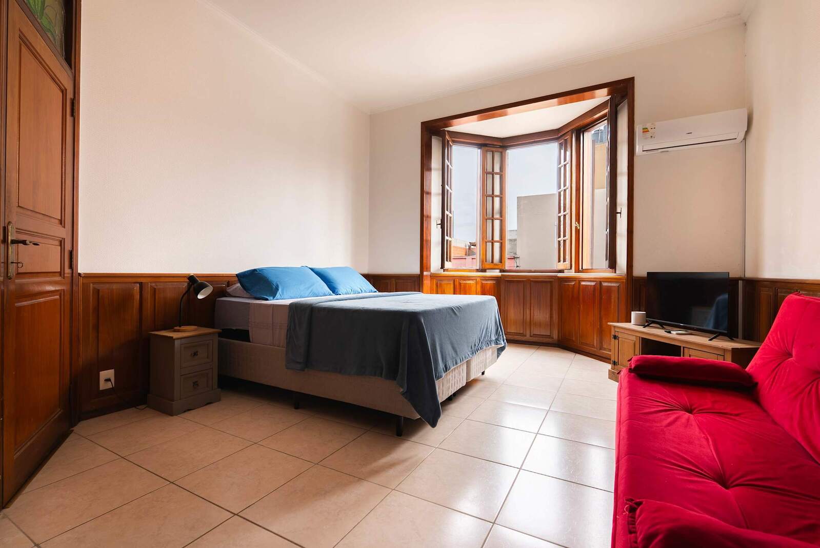 Bedroom with Queen Bed and Red Sofa