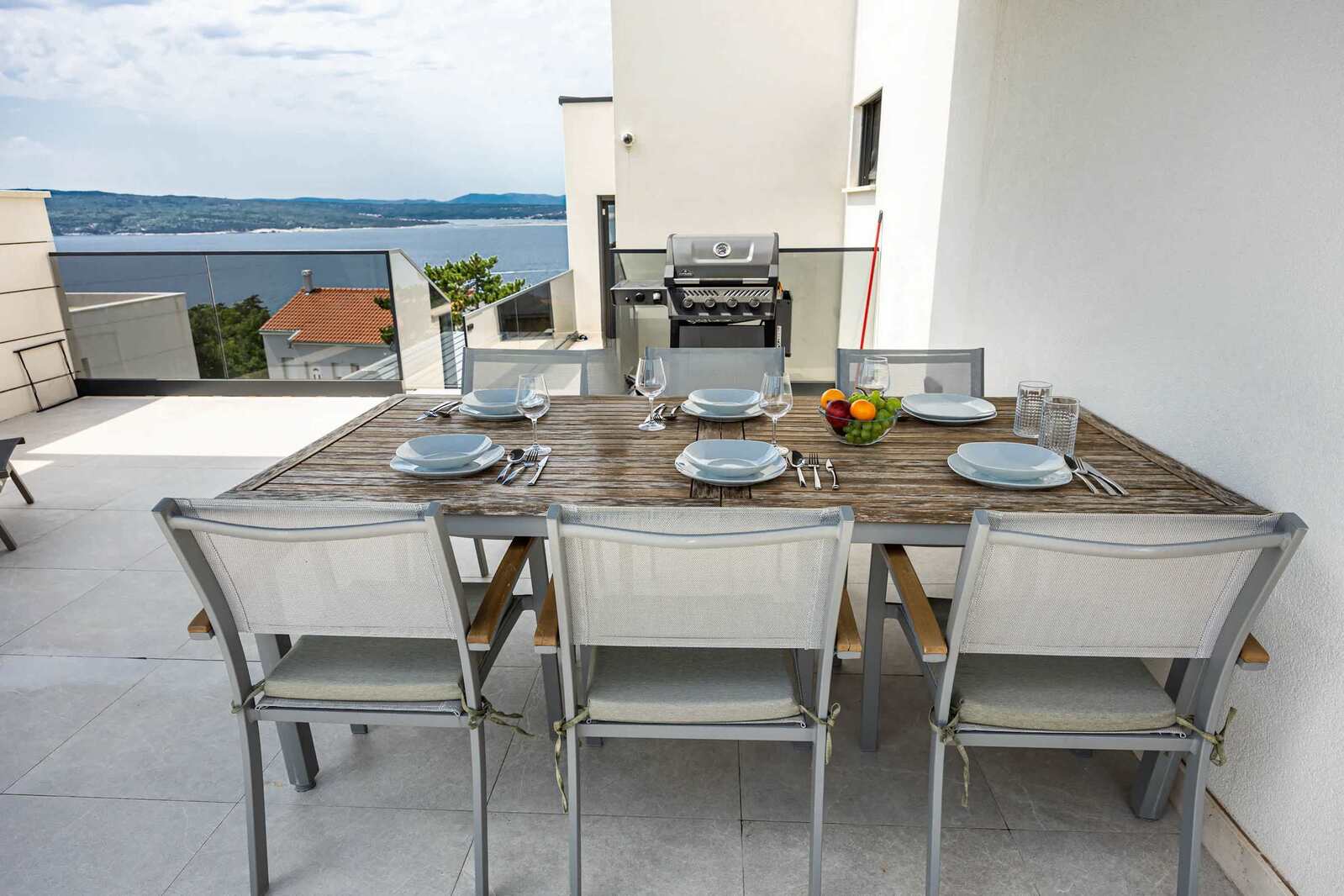 Outdoor dining table with gas BBQ and sea view