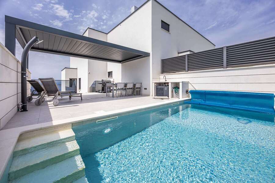 Heated pool with entry steps, outdoor shower and pergola
