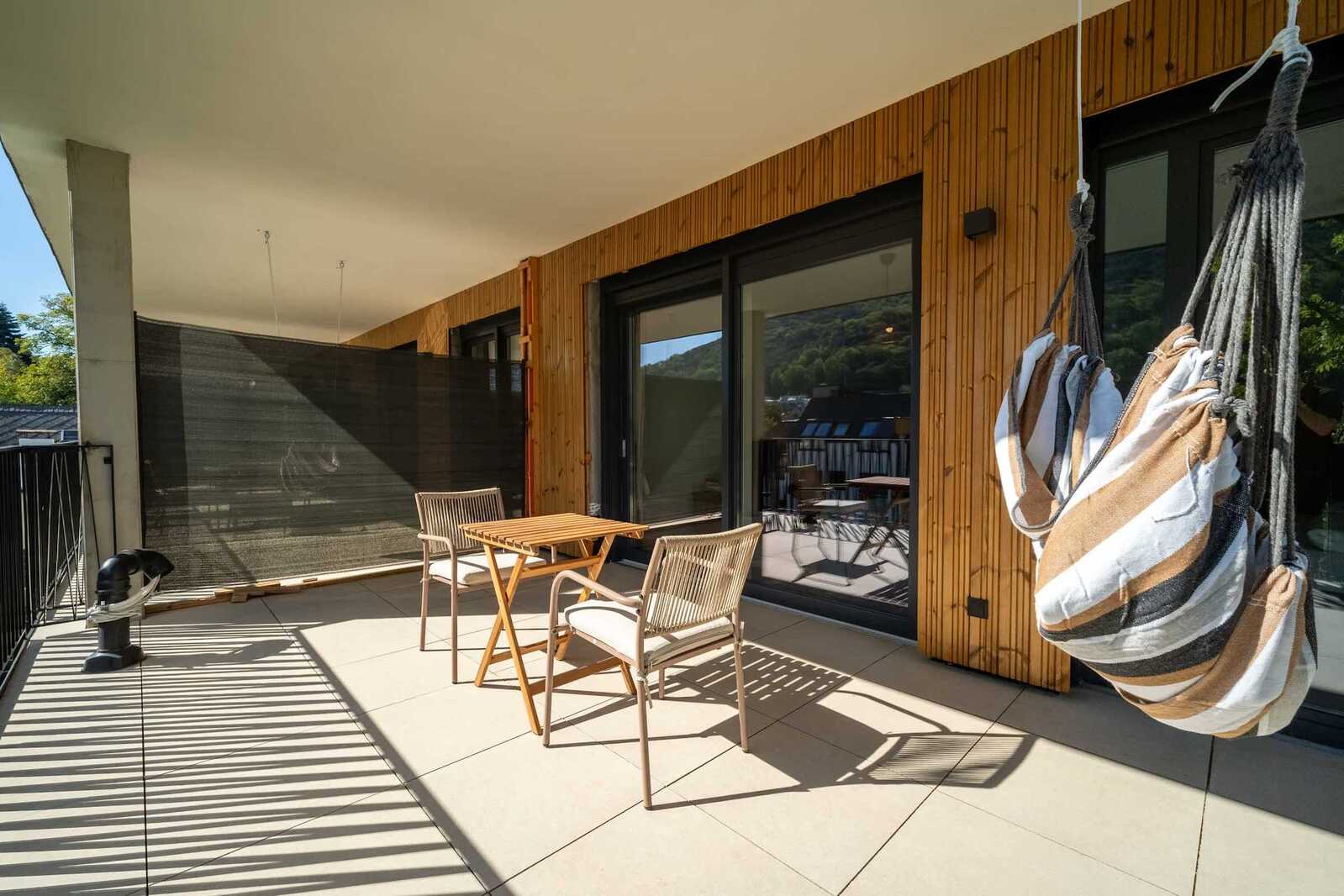 Balcony with hanging chair and outdoor dining
