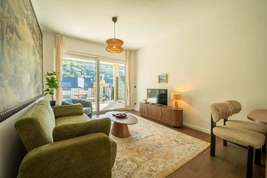 Living room with TV and doors to the balcony