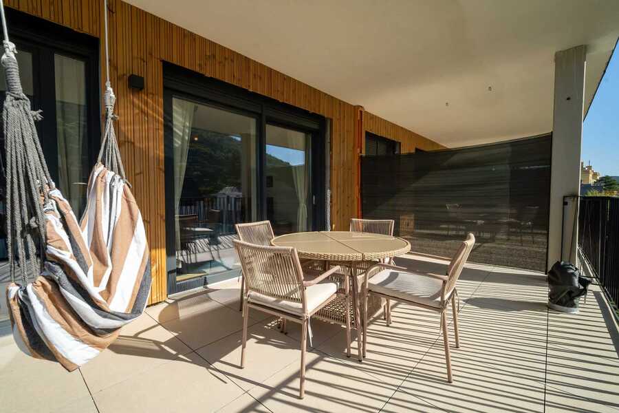 Balcony with hanging chairs and dining table