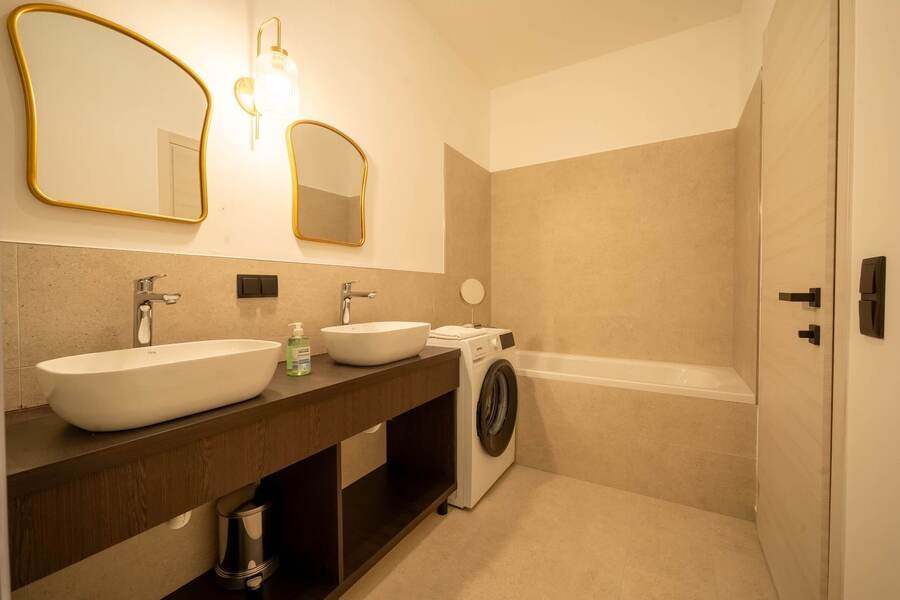 Bathroom with bathtub and twin washbasins