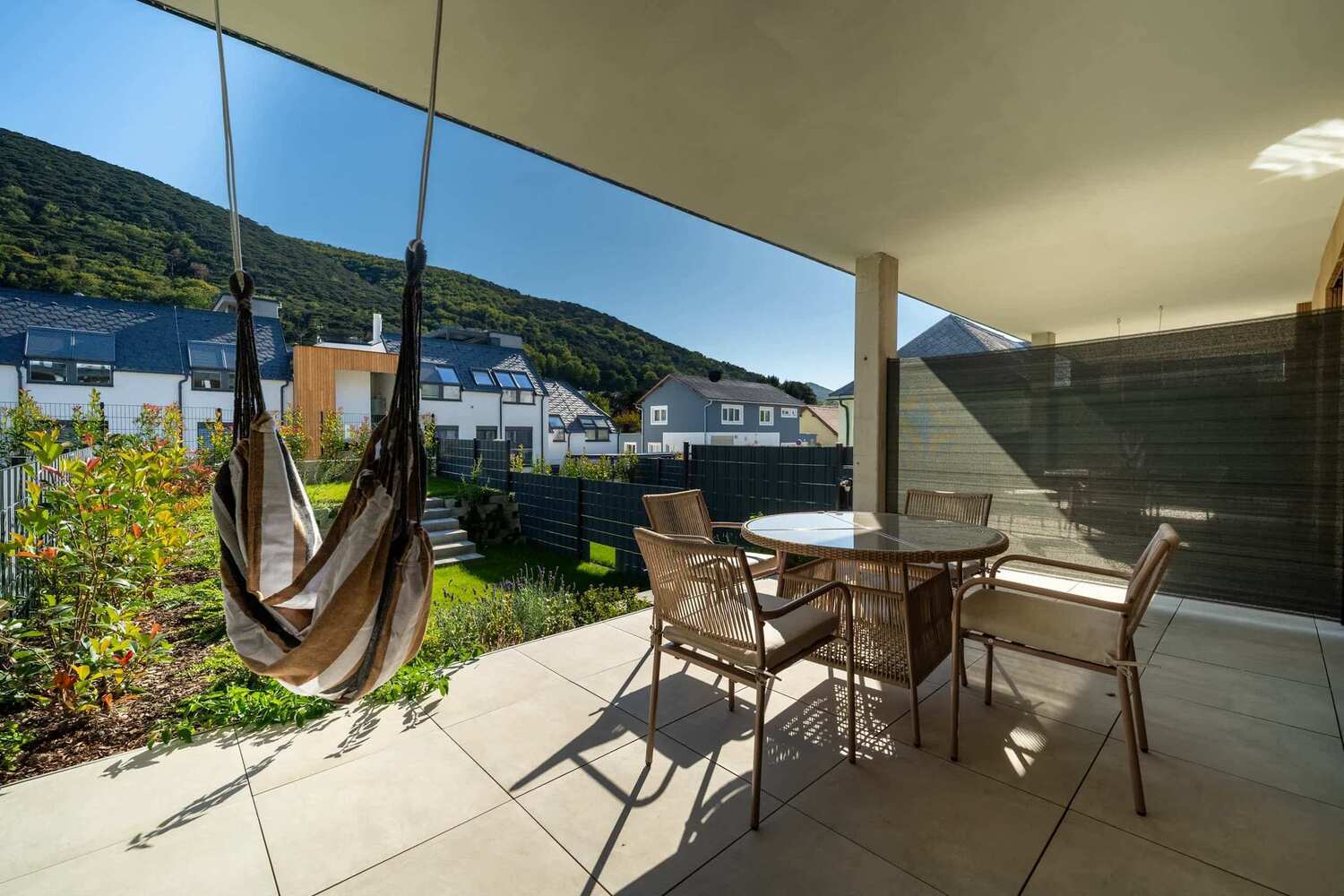 Terrace with hanging chair and views of the wooded hills