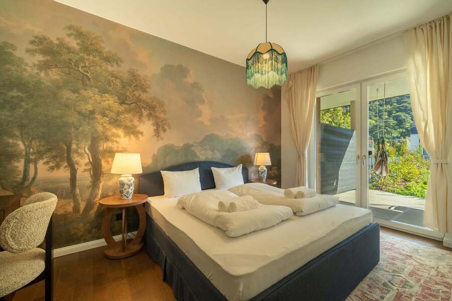 Bedroom with landscape mural and doors to the terrace