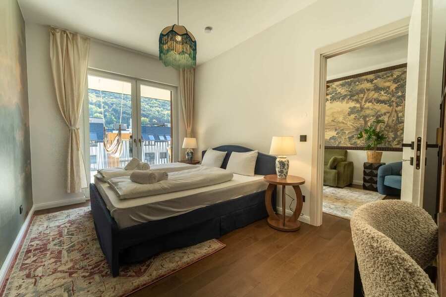 Bedroom with French windows and hill views