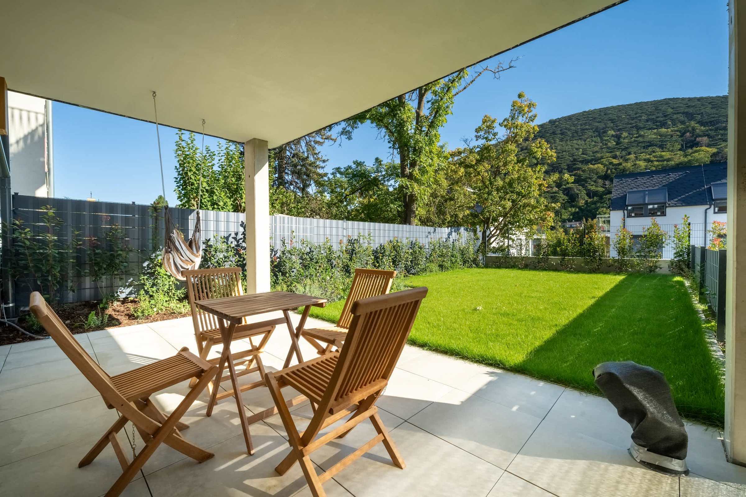 Covered terrace with outdoor dining and a private lawn