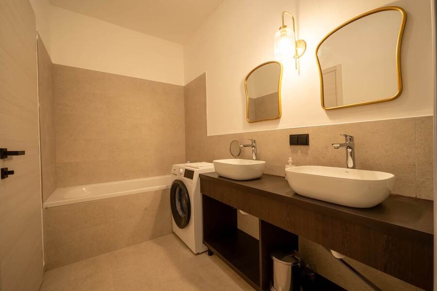 Bathroom with bathtub and twin washbasins
