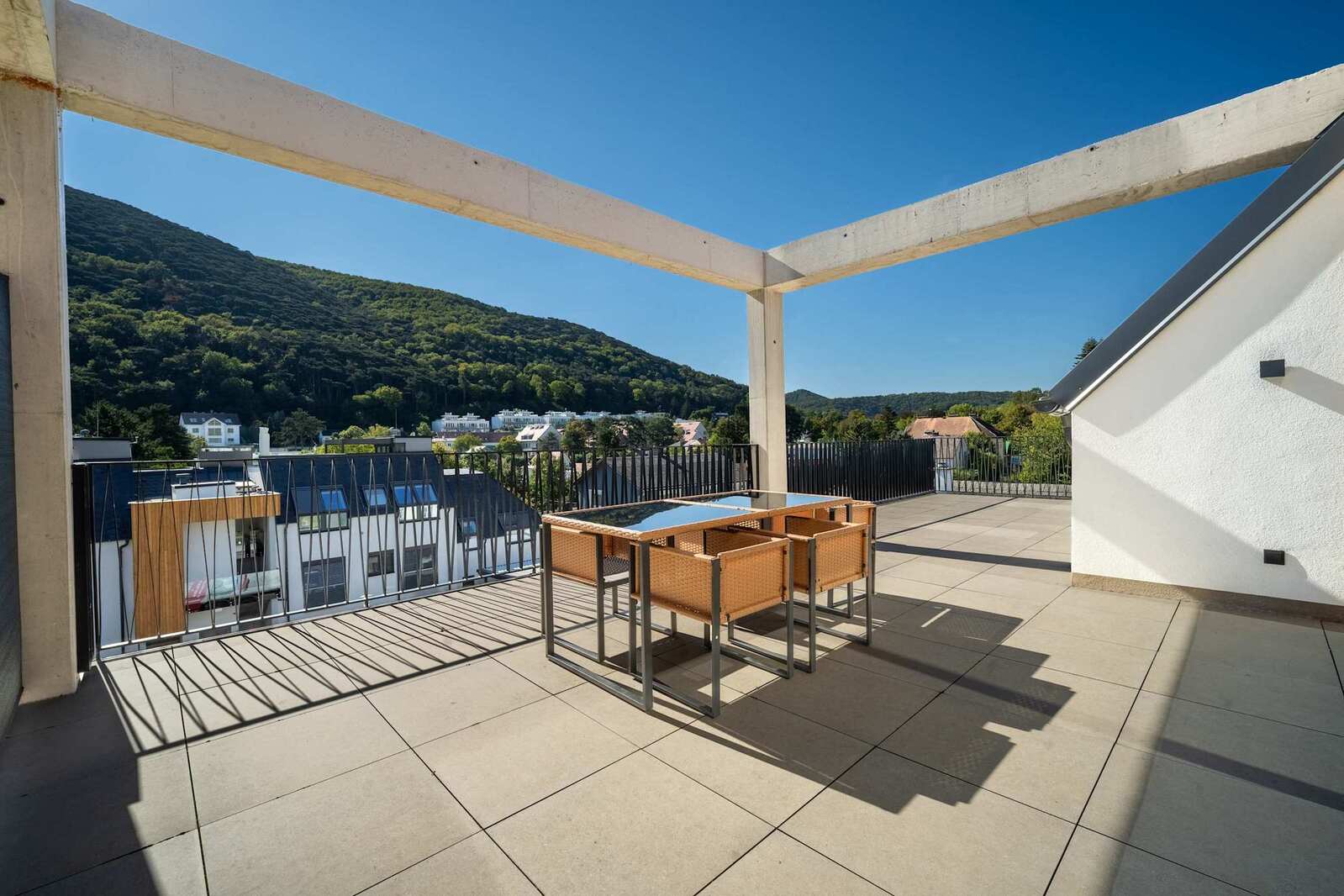 Private top-floor terrace with outdoor dining and views of the wooded hills